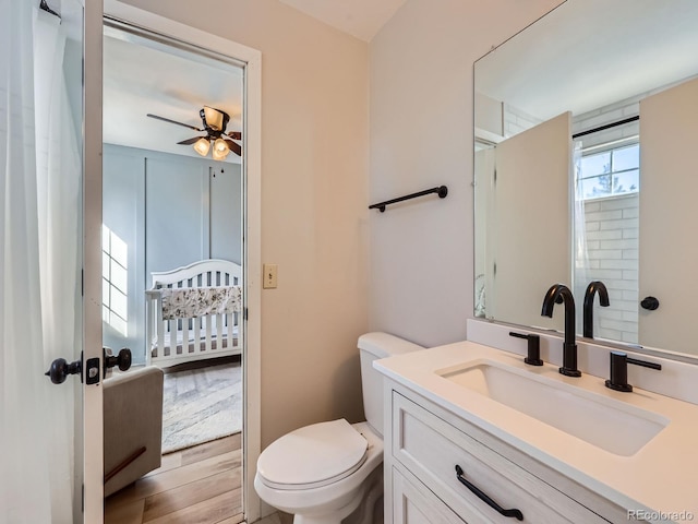 bathroom featuring wood-type flooring, vanity, toilet, and ceiling fan