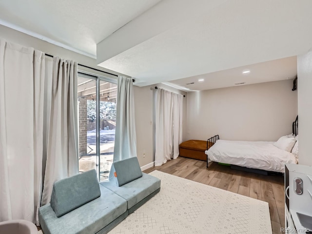 bedroom featuring light wood-type flooring and access to outside