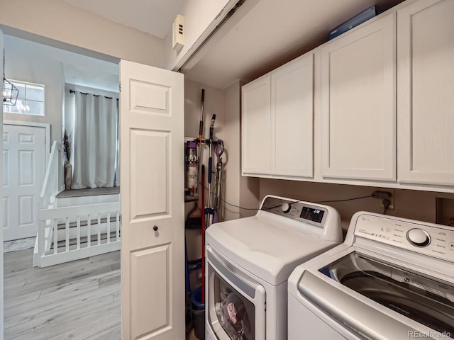 washroom with separate washer and dryer, cabinets, and light wood-type flooring