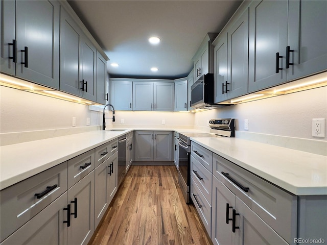 10025 W 8th Ave, Lakewood, CO 80215 - kitchen with stainless steel appliances, a sink, light wood-style flooring, recessed lighting, and light countertops