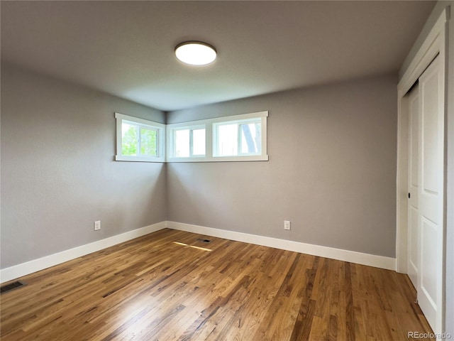 10025 W 8th Ave, Lakewood, CO 80215 - unfurnished bedroom with a closet, baseboards, and wood finished floors