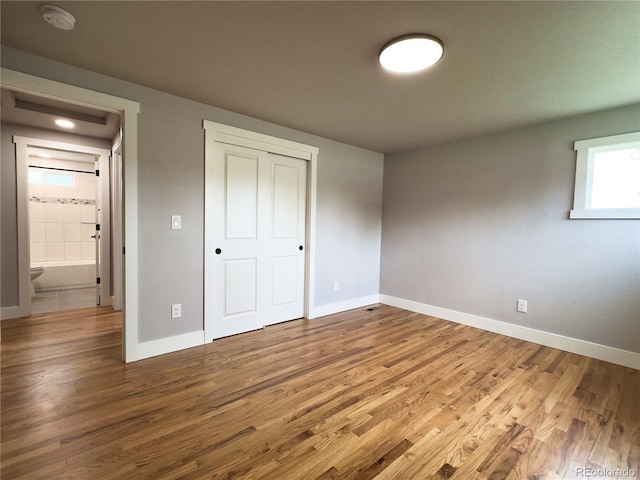 10025 W 8th Ave, Lakewood, CO 80215 - unfurnished bedroom featuring baseboards, wood finished floors, and a closet