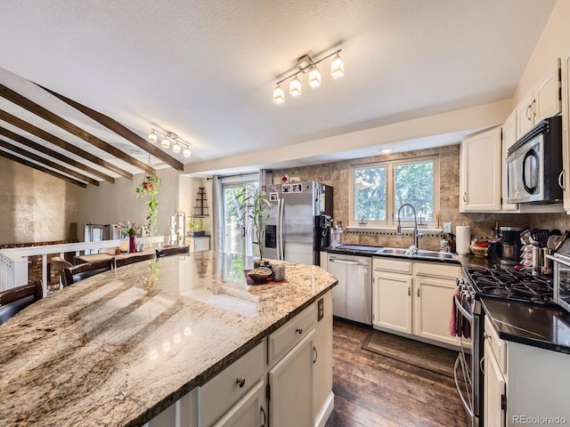 9150 Garrison St, Broomfield, CO 80021 - kitchen featuring appliances with stainless steel finishes, a sink, dark wood-style floors, and healthy amount of natural light