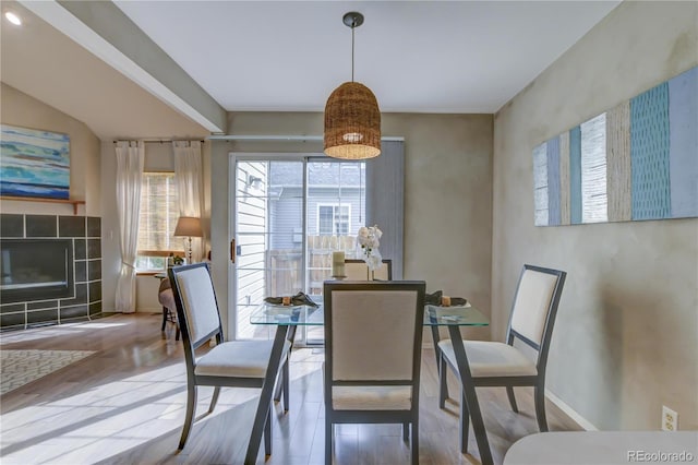 dining area featuring a fireplace and wood-type flooring