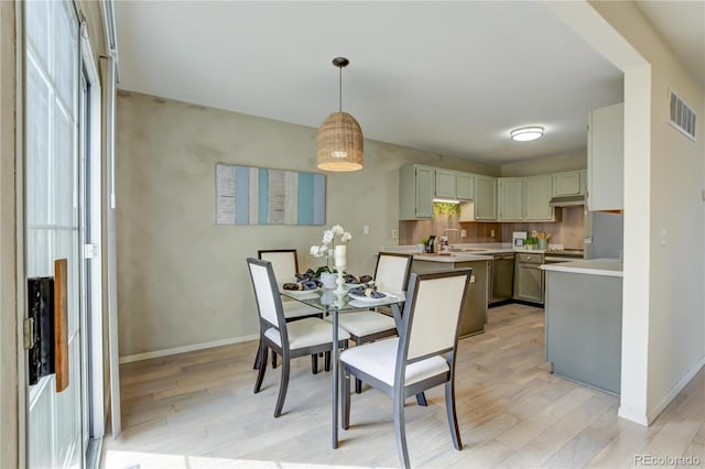 dining room with sink and light wood-type flooring