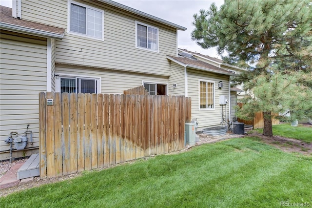 back of house with a yard and cooling unit