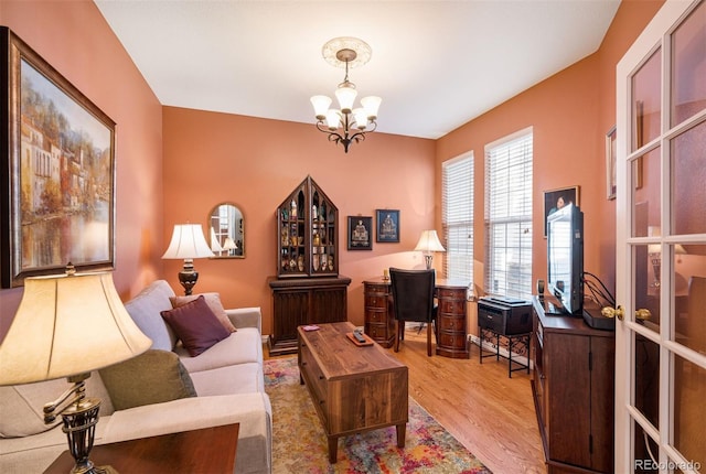 living room with a notable chandelier and light hardwood / wood-style floors