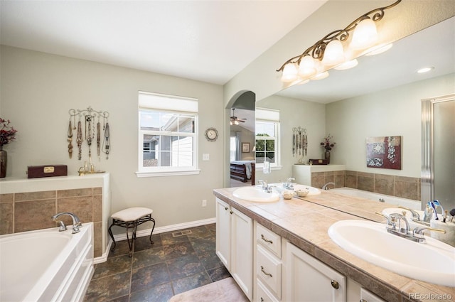 bathroom featuring vanity, ceiling fan, and a bathtub