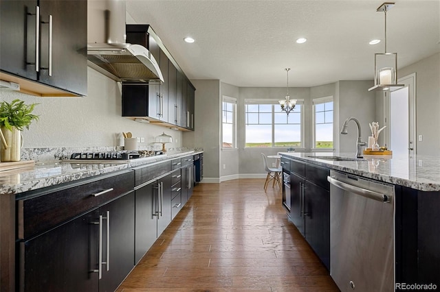 7606 S Valleyhead Ct, Aurora, CO 80016 - kitchen with appliances with stainless steel finishes, exhaust hood, dark wood-type flooring, recessed lighting, and a kitchen island with sink