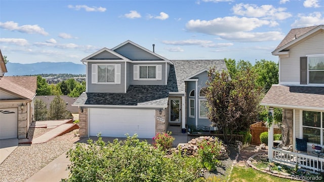 6510 Packsaddle Ct, Colorado Springs, CO 80922 - view of front of home featuring a shingled roof, an attached garage, a mountain view, and brick siding