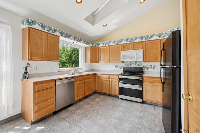 6510 Packsaddle Ct, Colorado Springs, CO 80922 - kitchen featuring stainless steel appliances, lofted ceiling, a skylight, light tile patterned floors, and tile countertops