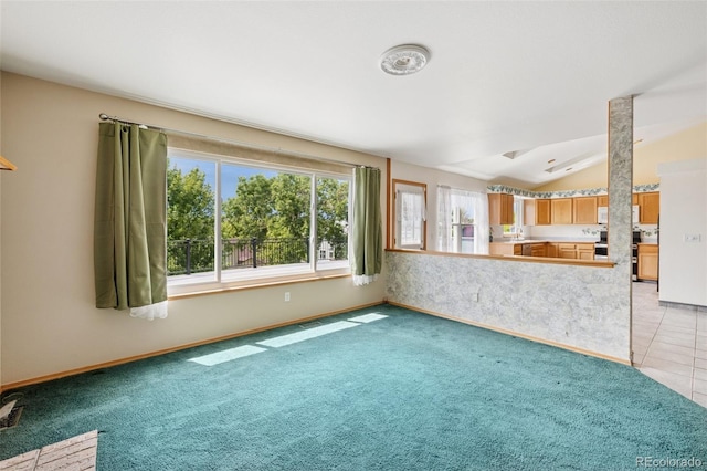 6510 Packsaddle Ct, Colorado Springs, CO 80922 - unfurnished living room featuring lofted ceiling, light colored carpet, and light tile patterned flooring