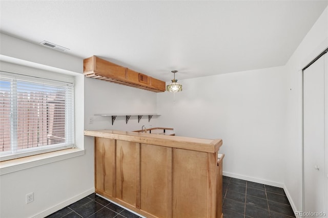 6510 Packsaddle Ct, Colorado Springs, CO 80922 - indoor wet bar with dark tile patterned floors and pendant lighting