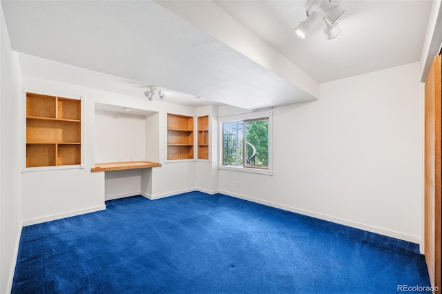 6510 Packsaddle Ct, Colorado Springs, CO 80922 - empty room with dark carpet, built in study area, and built in features
