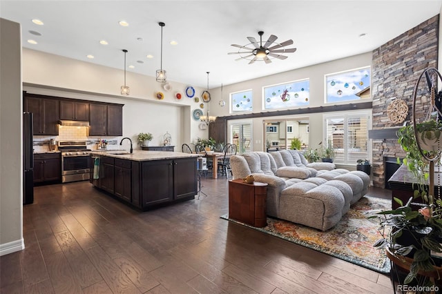 13833 Rivercrest Cir, Colorado Springs, CO 80921 - living area with ceiling fan, dark wood-type flooring, a stone fireplace, recessed lighting, and a high ceiling