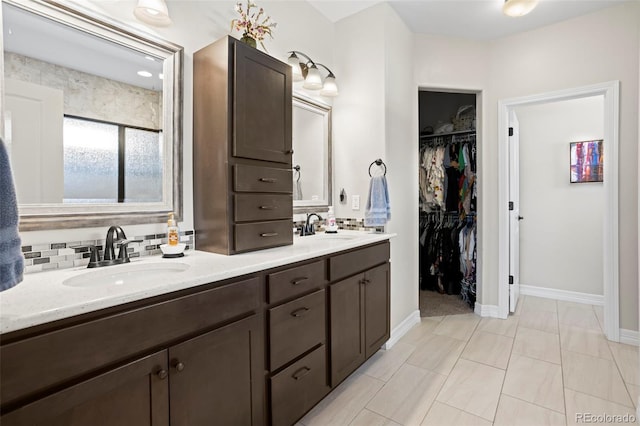 13833 Rivercrest Cir, Colorado Springs, CO 80921 - bathroom featuring double vanity, a spacious closet, and baseboards
