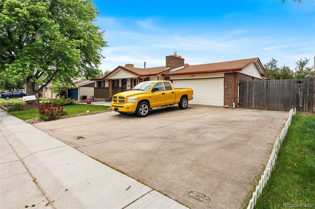 6336 W 71st Pl, Arvada, CO 80003 - view of front of home with an attached garage, brick siding, driveway, and a chimney