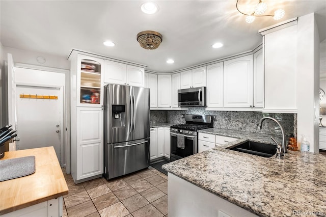 6336 W 71st Pl, Arvada, CO 80003 - kitchen featuring stainless steel appliances, light stone counters, white cabinets, tasteful backsplash, and recessed lighting