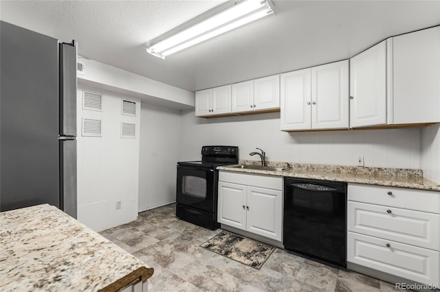 6336 W 71st Pl, Arvada, CO 80003 - kitchen with black appliances, white cabinetry, stone finish flooring, light stone counters, and a textured ceiling