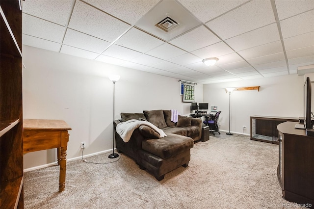 carpeted living room featuring a drop ceiling