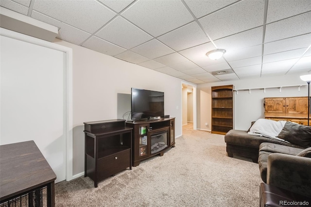 carpeted living room featuring a drop ceiling