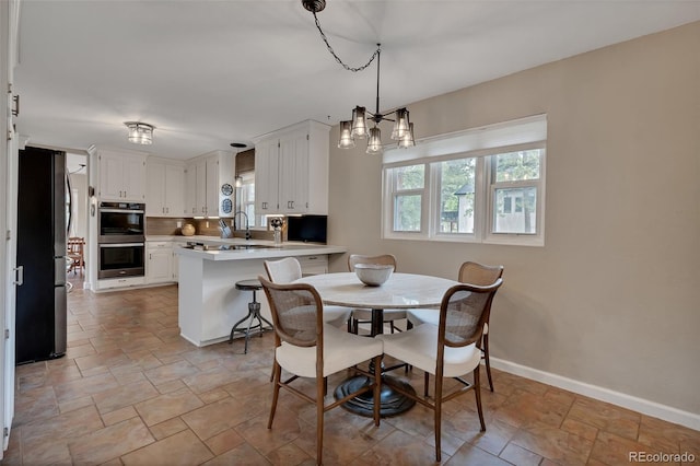 1540 Fawnwood Rd, Monument, CO 80132 - dining room featuring light stone finish floors, baseboards, and a chandelier