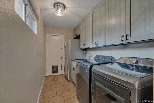1540 Fawnwood Rd, Monument, CO 80132 - laundry room with stone finish floors, cabinet space, washing machine and clothes dryer, and baseboards