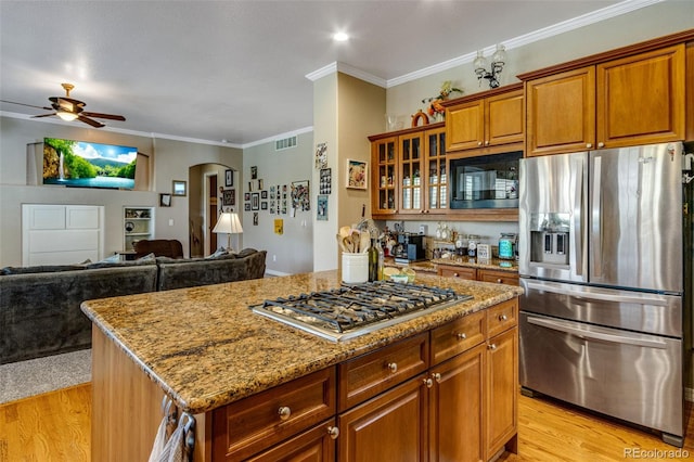 kitchen with visible vents, arched walkways, ceiling fan, appliances with stainless steel finishes, and light wood-style flooring