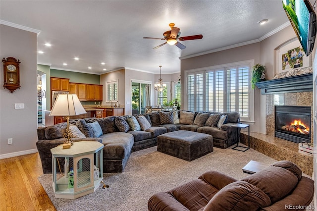 living area featuring a premium fireplace, baseboards, ornamental molding, and recessed lighting