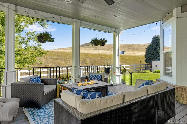 wooden deck with a mountain view and an outdoor living space with a fire pit