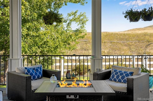 balcony with an outdoor living space with a fire pit