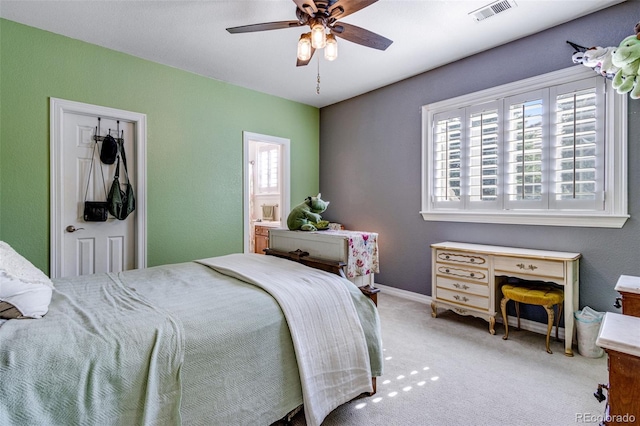carpeted bedroom featuring visible vents, a ceiling fan, and connected bathroom