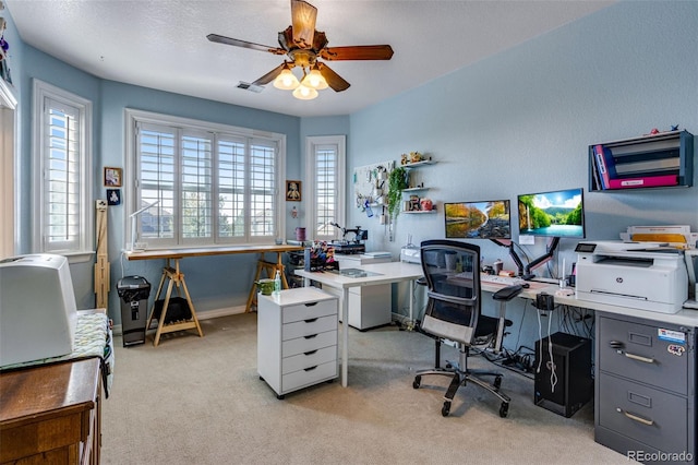 office space featuring light colored carpet, ceiling fan, baseboards, and visible vents