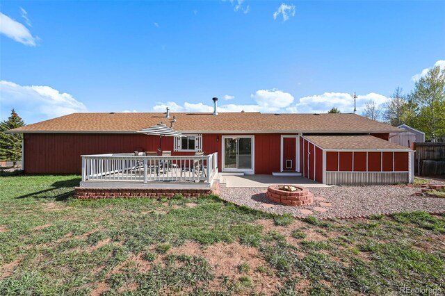1300 Thomas Cir, Woodland Park, CO 80863 - back of property with a fire pit, a lawn, a wooden deck, and roof with shingles