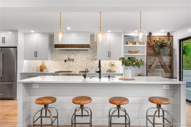3235 E Easter Pl, Centennial, CO 80122 - kitchen featuring appliances with stainless steel finishes, custom range hood, backsplash, and light stone countertops