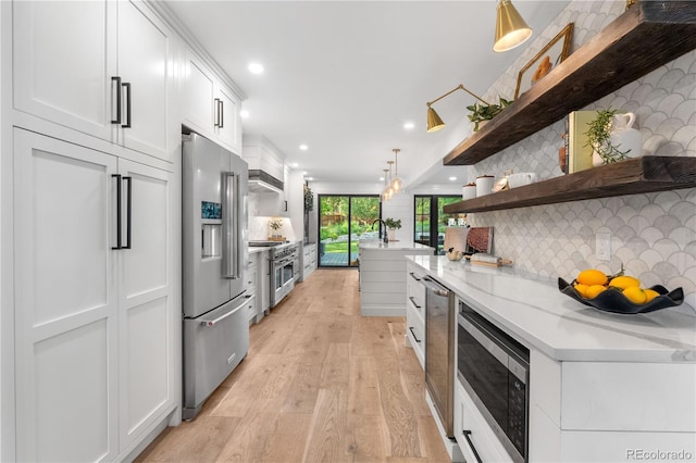 3235 E Easter Pl, Centennial, CO 80122 - kitchen with high quality appliances, light wood finished floors, open shelves, white cabinetry, and decorative backsplash