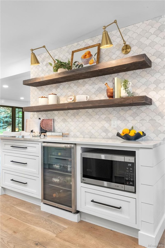 3235 E Easter Pl, Centennial, CO 80122 - bar area with beverage cooler, stainless steel microwave, and decorative backsplash