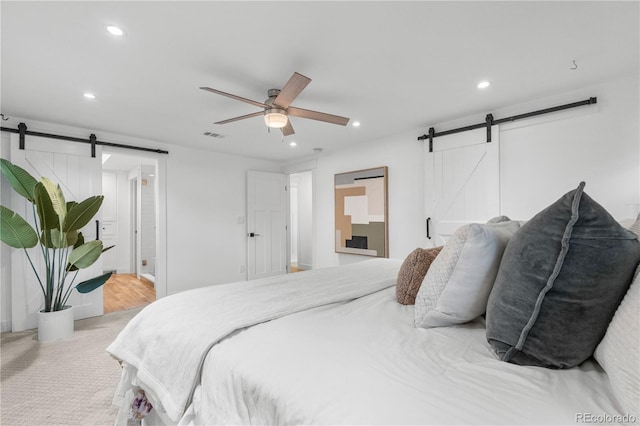 3235 E Easter Pl, Centennial, CO 80122 - bedroom with a barn door, recessed lighting, light carpet, connected bathroom, and ceiling fan