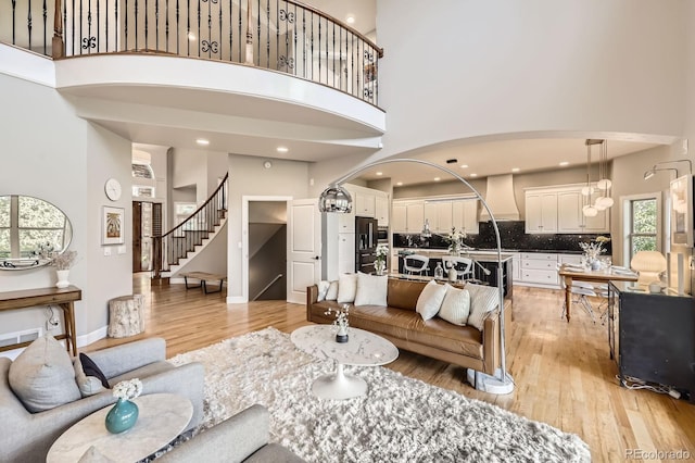 714 Skywalker Pt, Lafayette, CO 80026 - living room featuring a high ceiling, stairs, light wood-type flooring, and recessed lighting