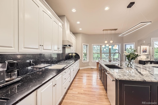 714 Skywalker Pt, Lafayette, CO 80026 - kitchen with light wood finished floors, stainless steel appliances, white cabinets, recessed lighting, and a center island with sink