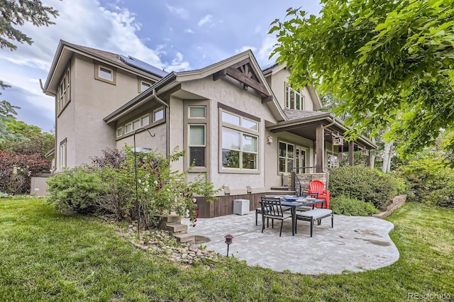 714 Skywalker Pt, Lafayette, CO 80026 - rear view of property featuring stucco siding, a lawn, and a patio area