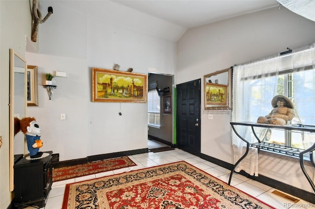 corridor featuring lofted ceiling and light tile patterned floors