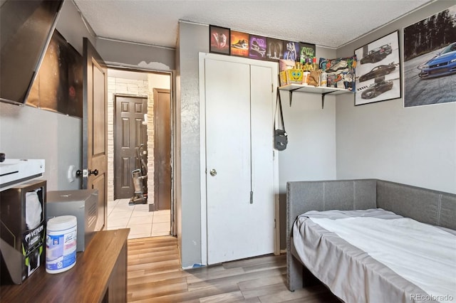 bedroom with a textured ceiling and light wood-type flooring