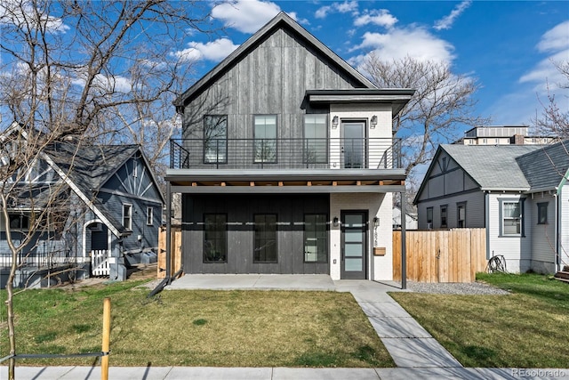 view of front of property with a front yard, a balcony, and a patio