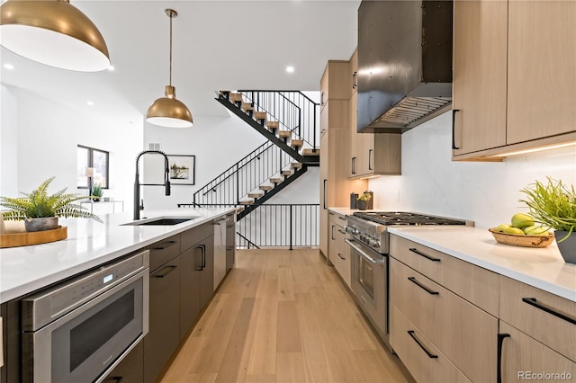 kitchen featuring sink, hanging light fixtures, stainless steel appliances, extractor fan, and light brown cabinetry