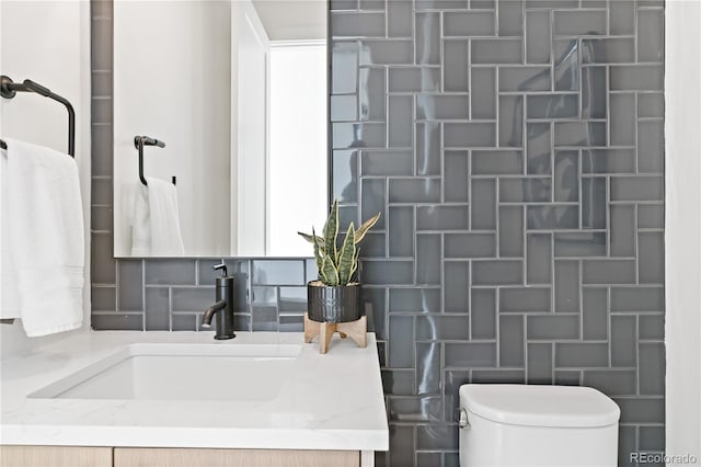 bathroom with backsplash, a shower, vanity, and toilet