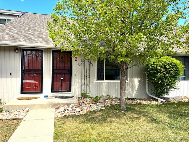 property entrance featuring a lawn