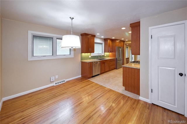 7140 S Uinta St, Centennial, CO 80112 - kitchen with appliances with stainless steel finishes, a sink, brown cabinets, baseboards, and recessed lighting