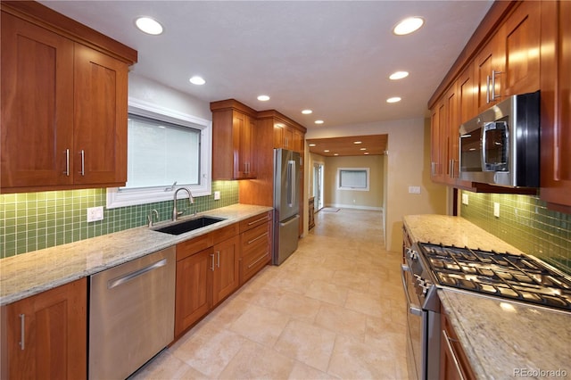7140 S Uinta St, Centennial, CO 80112 - kitchen with stainless steel appliances, a sink, light stone counters, recessed lighting, and brown cabinetry