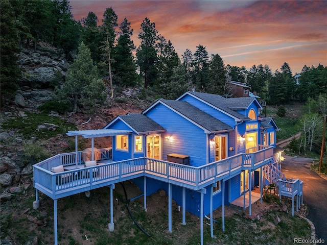 33633 Elk Run, Evergreen, CO 80439 - back of house at dusk featuring a deck and roof with shingles